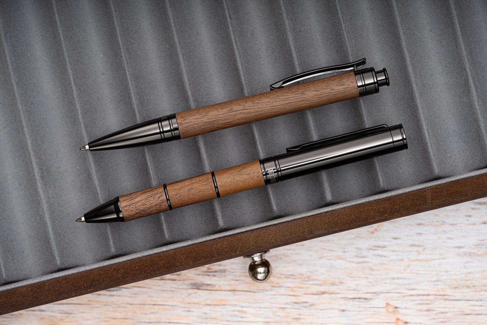 Bolígrafos de Hörner de madera y metal sobre un escritorio, junto a un cuaderno