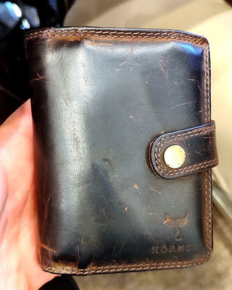 Cartera Fortis de piel de cabra marrón, visiblemente oscurecida tras varios meses de uso